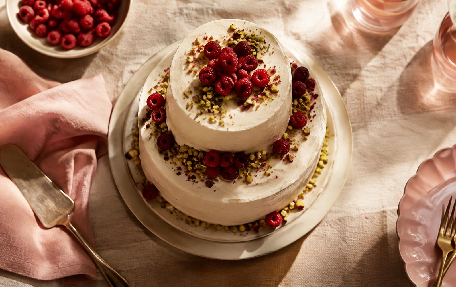 Two-tier cream cake with raspberries and pistachio